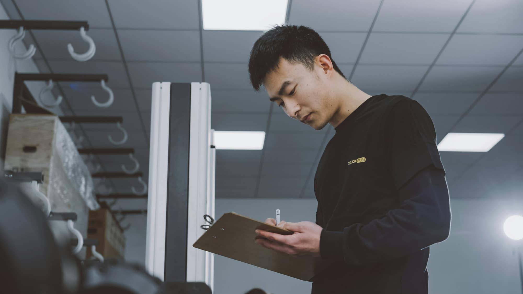 A tradesman with a clipboard noting down the details of a job